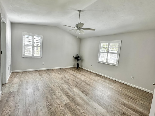 unfurnished room featuring vaulted ceiling, ceiling fan, baseboards, and wood finished floors