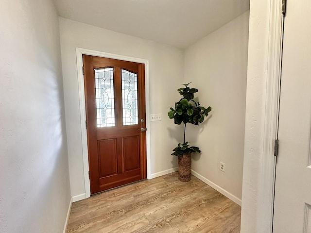 foyer entrance featuring light wood-style flooring and baseboards