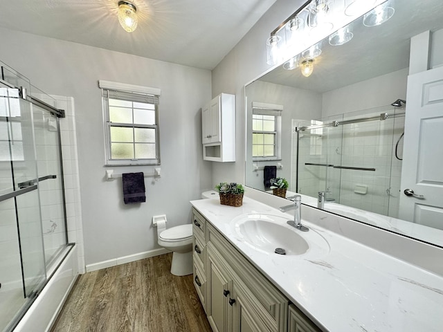 full bathroom featuring a wealth of natural light, toilet, vanity, and wood finished floors