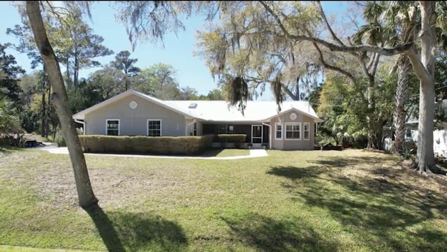 rear view of property featuring a lawn