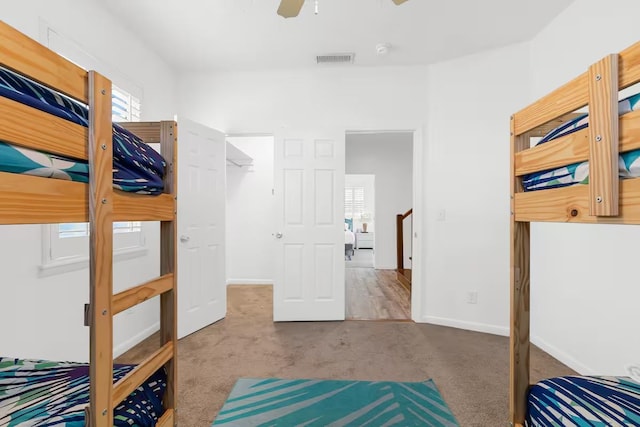 bedroom featuring multiple windows, ceiling fan, a closet, and carpet floors