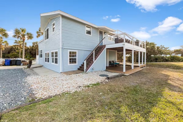 back of house with a lawn and a balcony