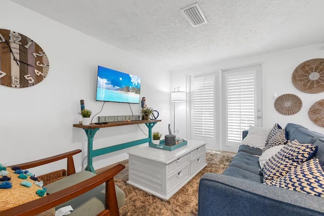 living room featuring carpet floors and a textured ceiling