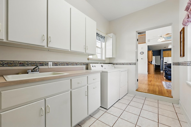 laundry room with light tile patterned floors, a sink, a ceiling fan, washer and dryer, and cabinet space