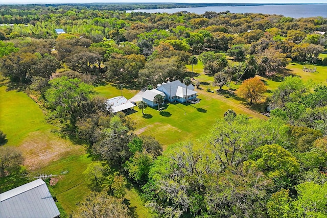 aerial view with a water view and a wooded view