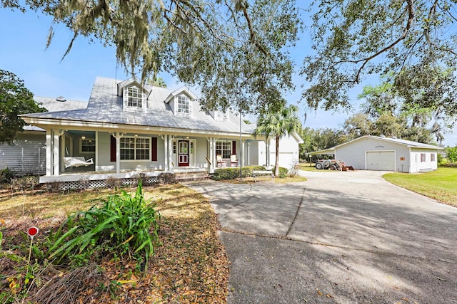 view of front of home featuring covered porch, a detached garage, and an outdoor structure