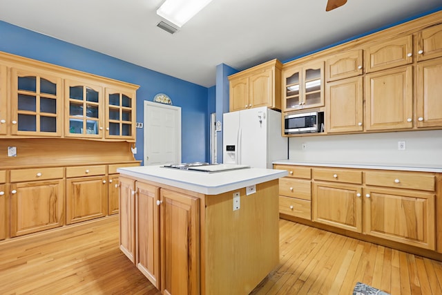 kitchen with light wood finished floors, visible vents, white fridge with ice dispenser, and stainless steel microwave