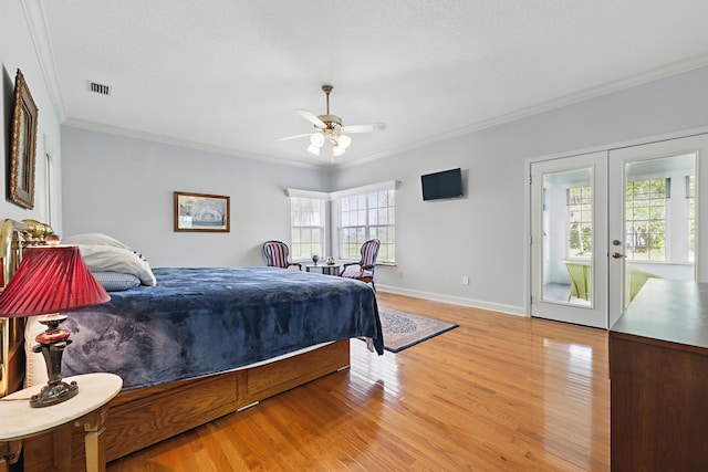 bedroom with light wood finished floors, baseboards, visible vents, crown molding, and french doors