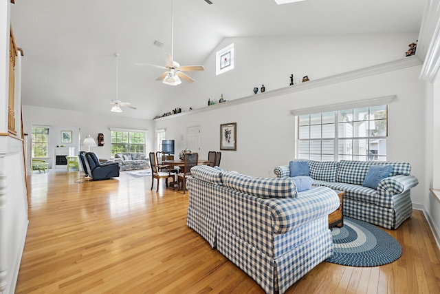 living room with ceiling fan, high vaulted ceiling, and light wood-type flooring