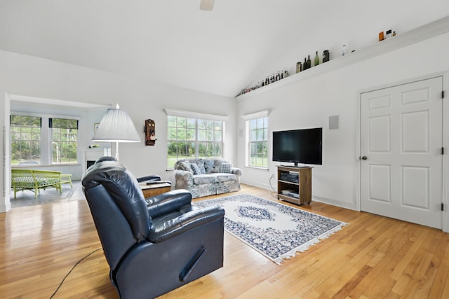 living area featuring light wood-type flooring, vaulted ceiling, and baseboards