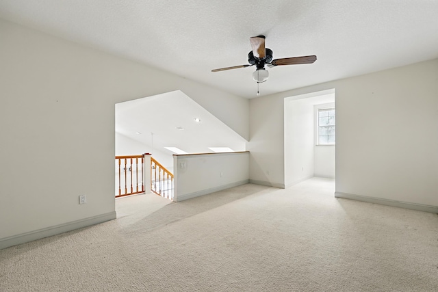 bonus room featuring ceiling fan, a textured ceiling, carpet flooring, and baseboards