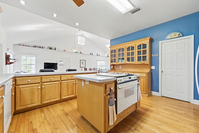 kitchen with a ceiling fan, a center island, white appliances, and light countertops