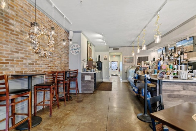 bar featuring pendant lighting and brick wall