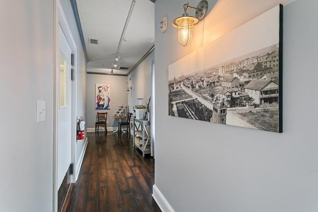 hallway featuring crown molding, dark hardwood / wood-style flooring, and a textured ceiling