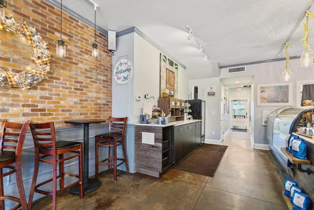 kitchen with a kitchen breakfast bar, dark brown cabinetry, hanging light fixtures, and brick wall