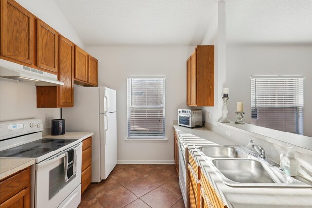 kitchen featuring dishwashing machine, electric range, dark tile patterned floors, and sink