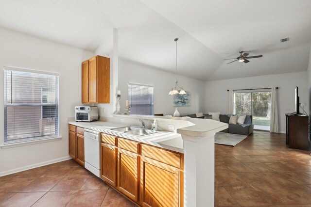 kitchen featuring pendant lighting, dishwasher, sink, vaulted ceiling, and kitchen peninsula