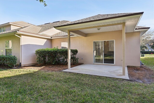 back of property with a yard and a patio