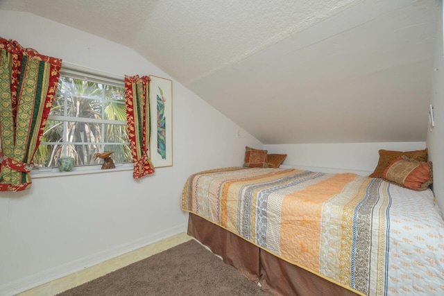 232 Riberia St, Saint Augustine, FL 32084 - bedroom with lofted ceiling, baseboards, and a textured ceiling