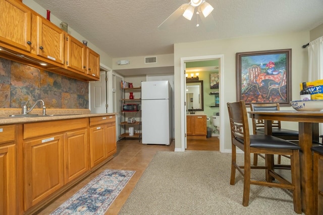 232 Riberia St, Saint Augustine, FL 32084 - kitchen with a sink, freestanding refrigerator, visible vents, light countertops, and tasteful backsplash