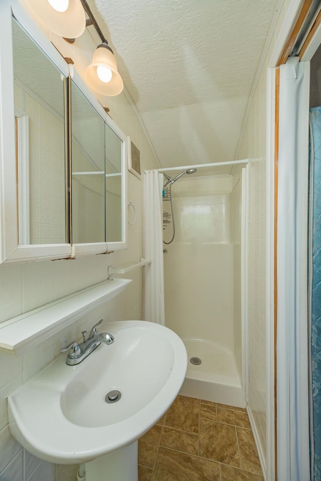 232 Riberia St, Saint Augustine, FL 32084 - bathroom featuring a textured ceiling, a shower stall, and a sink