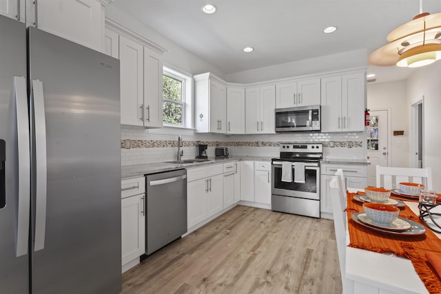 kitchen featuring white cabinetry, sink, stainless steel appliances, and light wood-type flooring