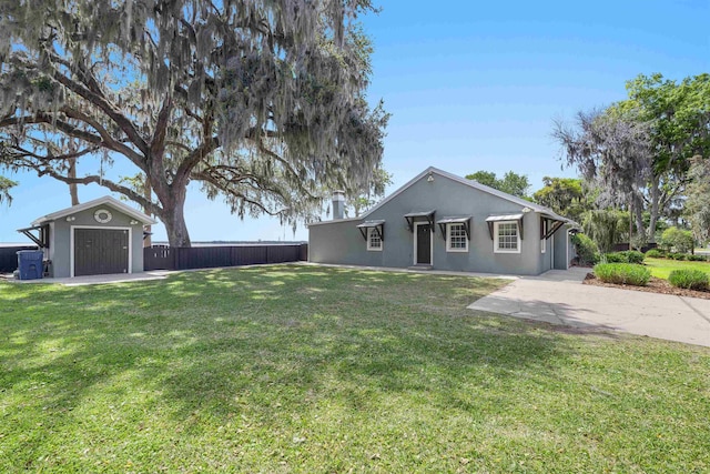 single story home featuring stucco siding, fence, and a front lawn