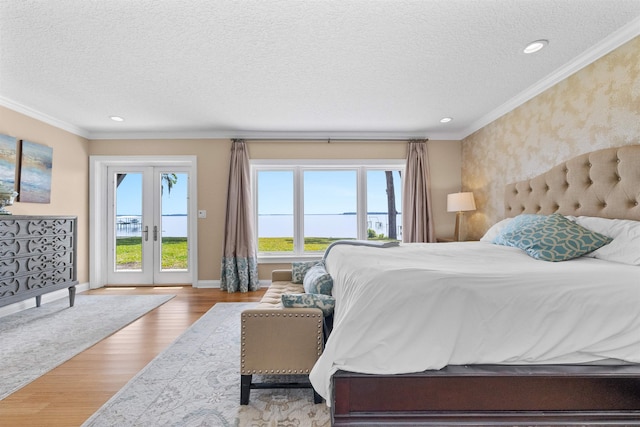 bedroom featuring french doors, wood finished floors, access to outside, baseboards, and ornamental molding
