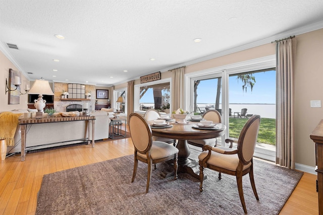 dining area with ornamental molding, visible vents, and light wood finished floors