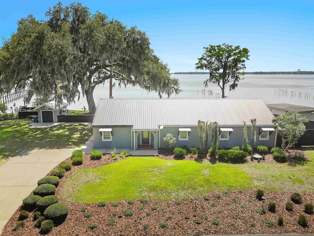 view of front of home featuring a front yard, stucco siding, and metal roof