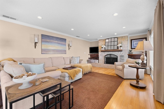living area featuring recessed lighting, hardwood / wood-style floors, ornamental molding, visible vents, and a fireplace