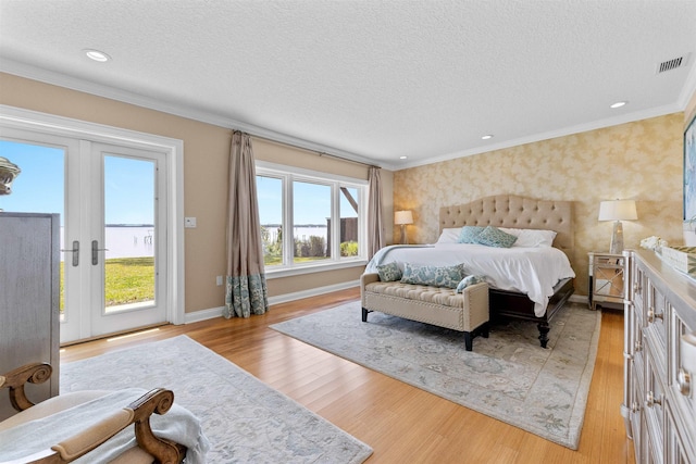bedroom featuring baseboards, a textured ceiling, access to exterior, visible vents, and light wood-style flooring