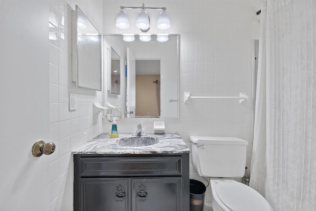 full bath featuring a shower with curtain, toilet, vanity, and tile walls