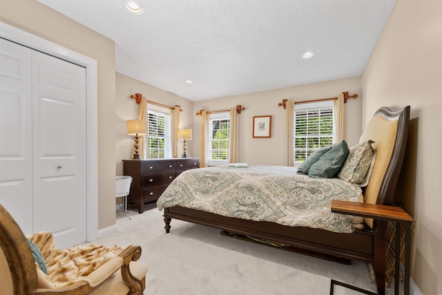 bedroom with recessed lighting, baseboards, light colored carpet, and a textured ceiling