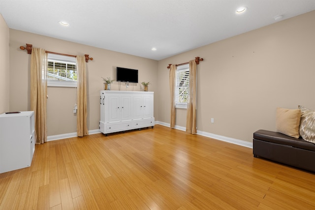 unfurnished room with baseboards, light wood-style floors, and a wealth of natural light