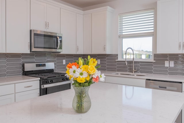 166 Fairlake Cir, Saint Augustine, FL 32092 - kitchen featuring appliances with stainless steel finishes, a sink, white cabinets, and tasteful backsplash