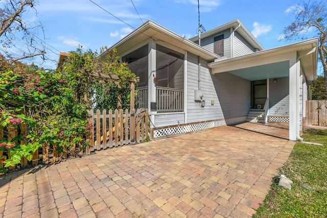 161 Blanco St, Saint Augustine, FL 32084 - rear view of house with entry steps, a sunroom, and fence