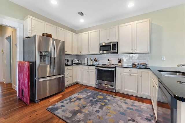 161 Blanco St, Saint Augustine, FL 32084 - kitchen with visible vents, dark countertops, appliances with stainless steel finishes, a sink, and backsplash
