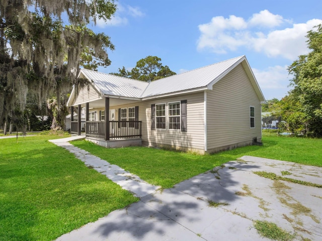 50 Spring St, Saint Augustine, FL 32084 - view of property exterior featuring a yard, covered porch, and a metal roof