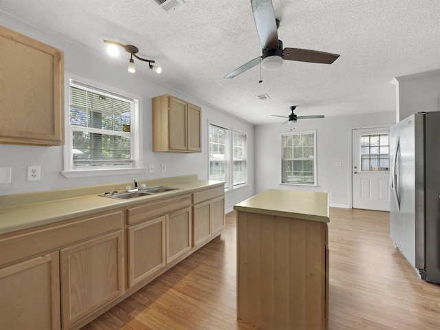 50 Spring St, Saint Augustine, FL 32084 - kitchen with freestanding refrigerator, light brown cabinetry, light wood finished floors, a textured ceiling, and a kitchen island