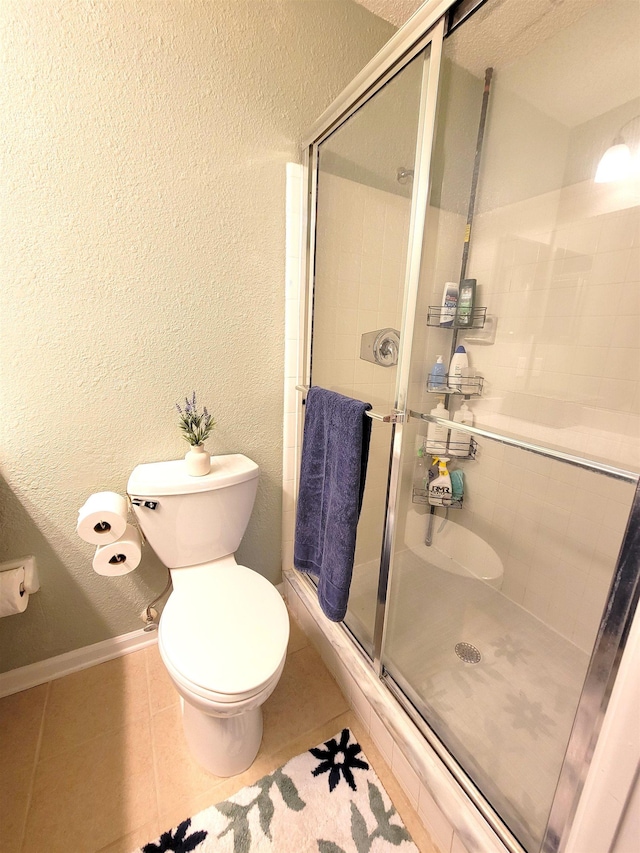 bathroom featuring tile patterned floors, toilet, a textured ceiling, and walk in shower