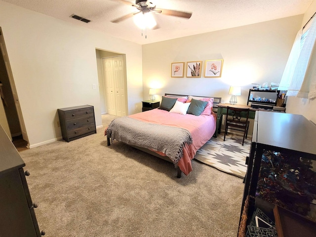 carpeted bedroom featuring ceiling fan and a closet