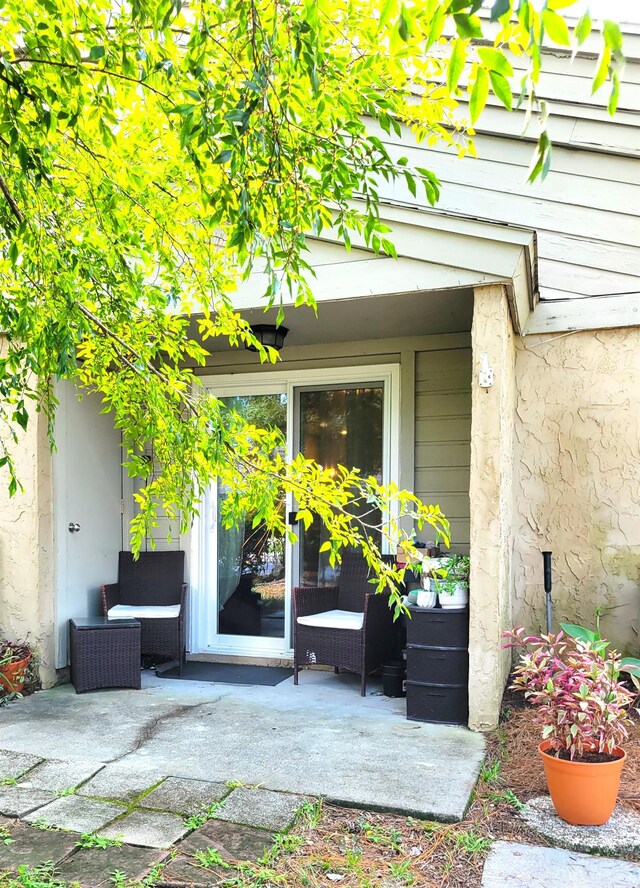 view of exterior entry with a patio area and an outdoor living space