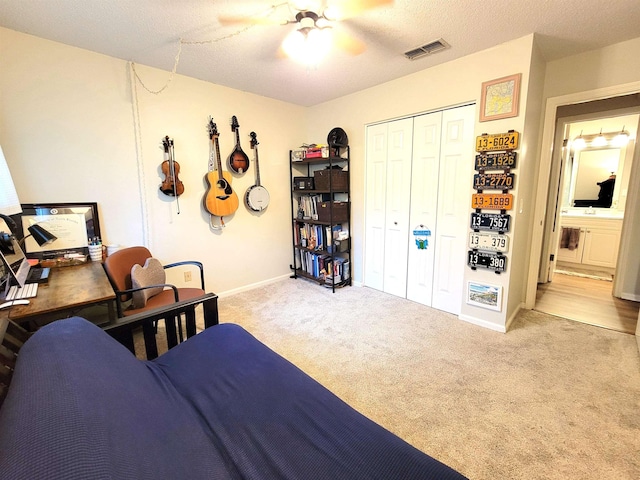 carpeted bedroom featuring a textured ceiling, a closet, and ceiling fan