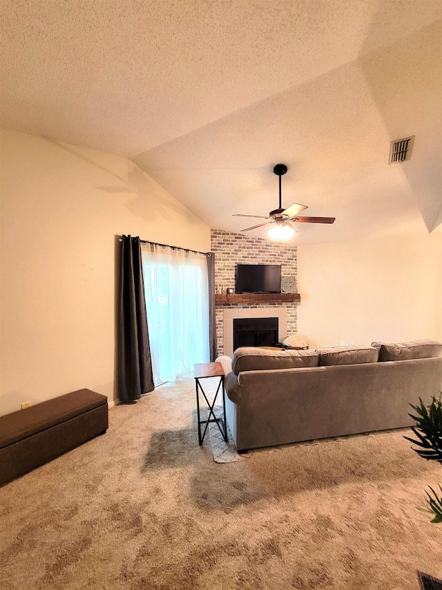 carpeted living room featuring a brick fireplace, ceiling fan, a textured ceiling, and vaulted ceiling