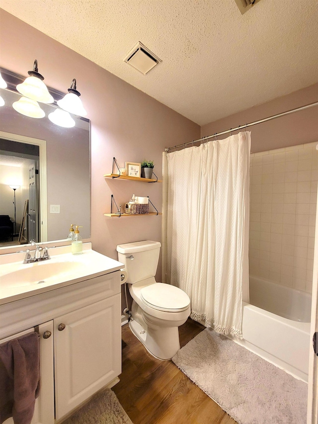 full bathroom featuring a textured ceiling, toilet, shower / tub combo with curtain, vanity, and hardwood / wood-style flooring