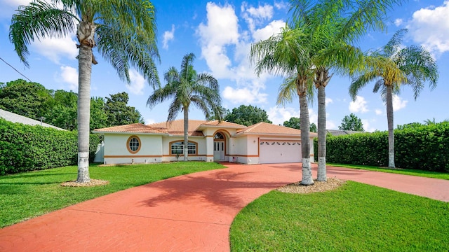53 Pritchard Dr, Palm Coast, FL 32164 - mediterranean / spanish house featuring curved driveway, stucco siding, an attached garage, a front lawn, and a tiled roof