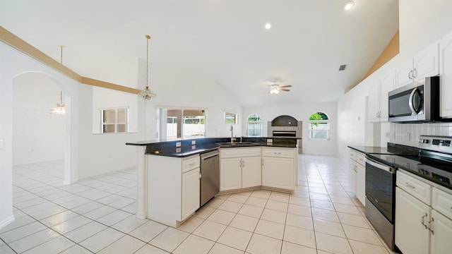 53 Pritchard Dr, Palm Coast, FL 32164 - kitchen with stainless steel appliances, ceiling fan, arched walkways, dark countertops, and open floor plan