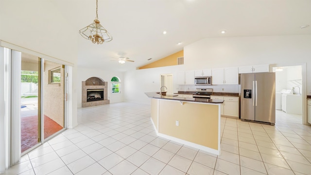 53 Pritchard Dr, Palm Coast, FL 32164 - kitchen featuring stainless steel appliances, washer and dryer, open floor plan, ceiling fan, and high vaulted ceiling