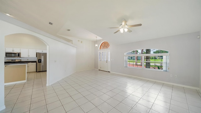 53 Pritchard Dr, Palm Coast, FL 32164 - unfurnished living room with ceiling fan, arched walkways, and light tile patterned floors